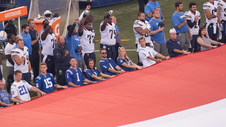 San Diego Chargers players raise their fist during the national anthem