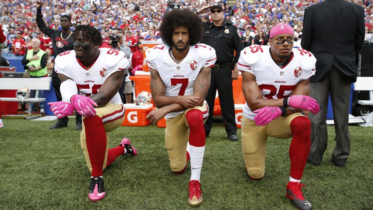 Colin Kaepernick and teammates Eli Herald and Eric Reid kneeling during the national anthem