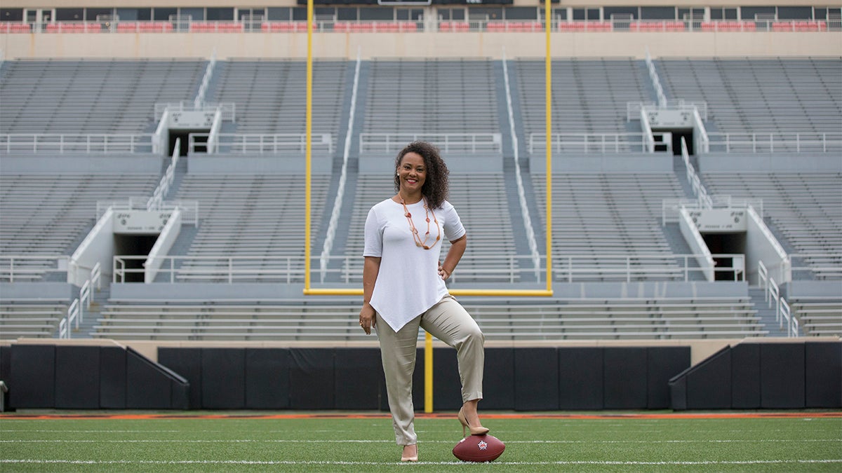 Patsy Armstrong standing on a football