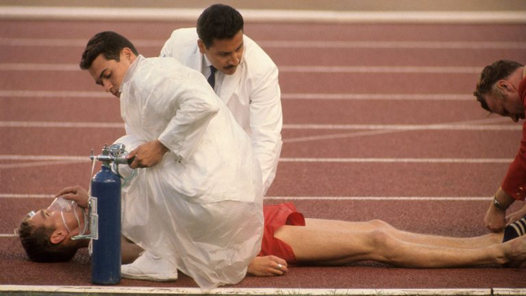 A runner on the track is given oxygen after collapsing during race