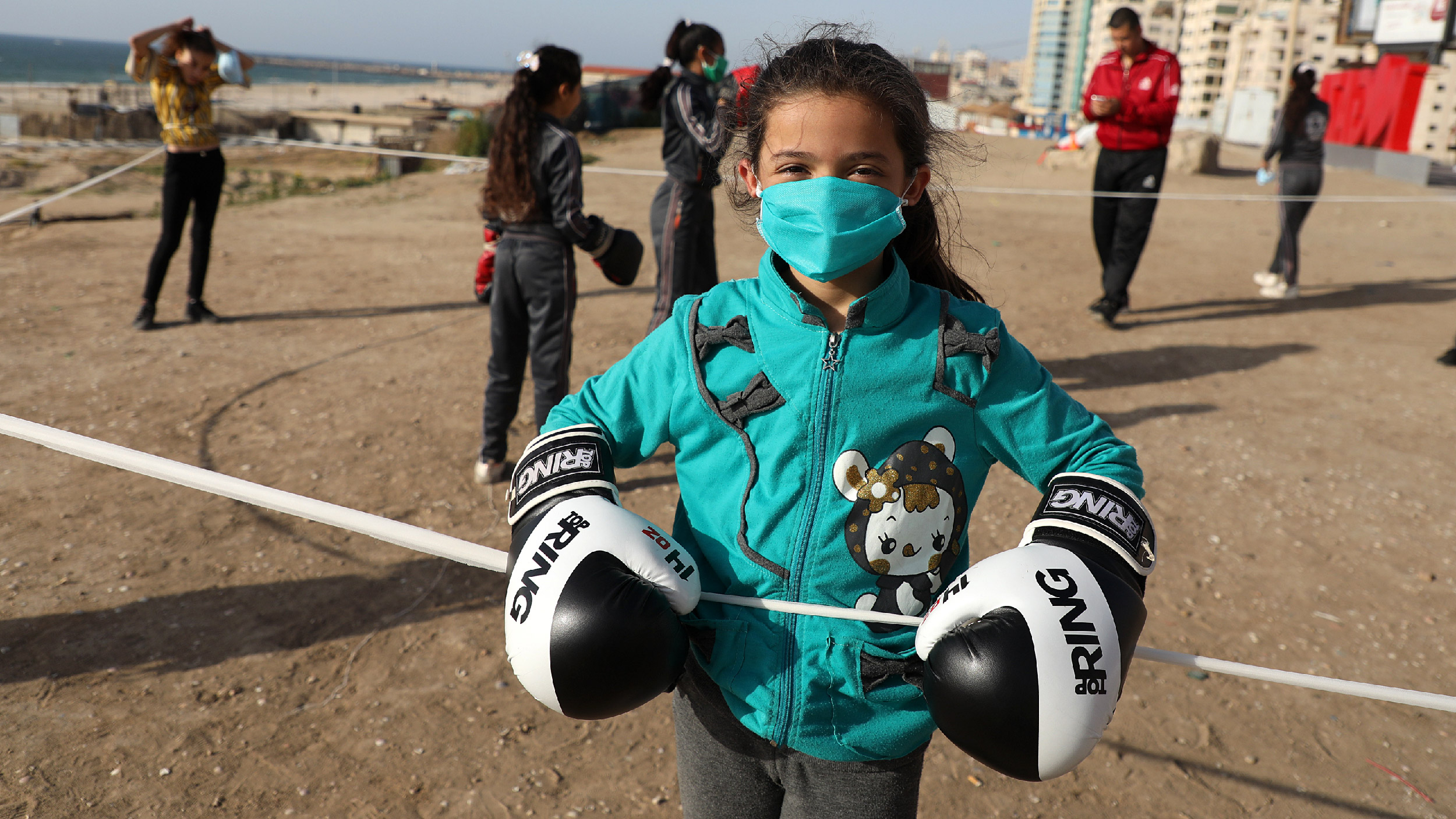 Palestinian girls clad in masks due to the COVID-19 coronavirus pandemic take part in an open-air boxing training near the beach in Gaza City on May 12, 2020. (Photo by Majdi Fathi/NurPhoto via Getty Images)