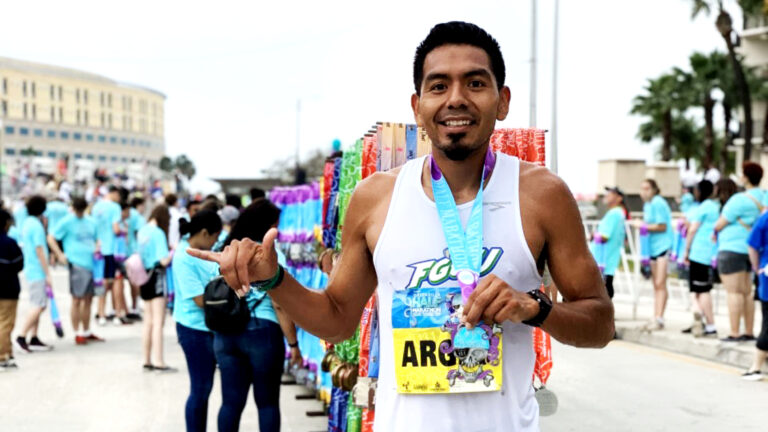 Argeo Cruz poses with a medal around his neck after finishing a race. (Photo courtesy Argeo Cruz)