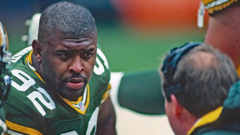 Green Bay Packers player Reggie White talking to head coach, Mike Holmgren.