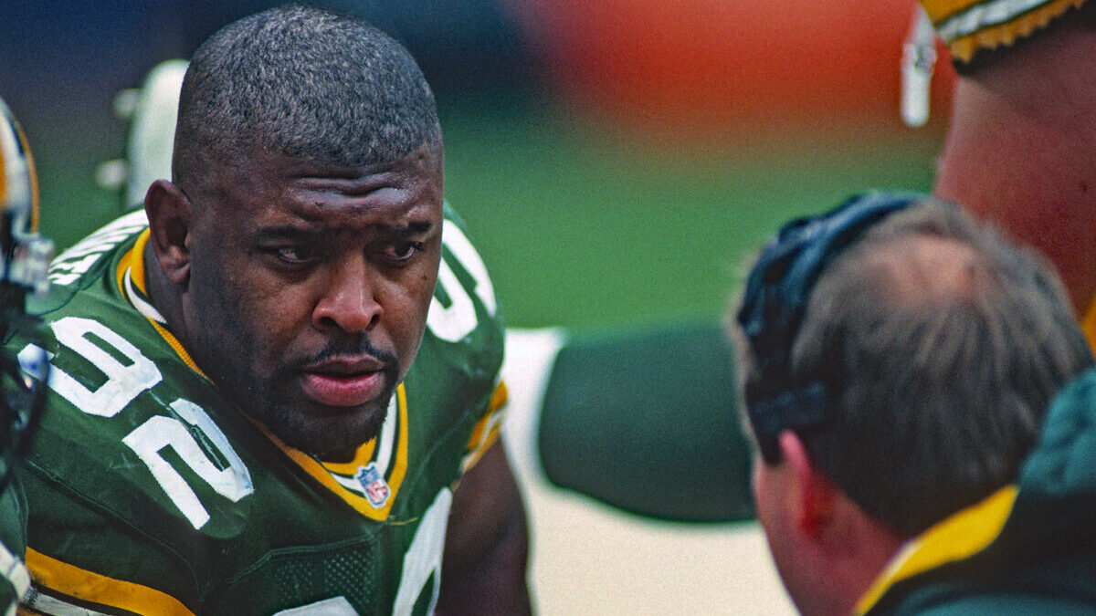 Green Bay Packers player Reggie White talking to head coach, Mike Holmgren.