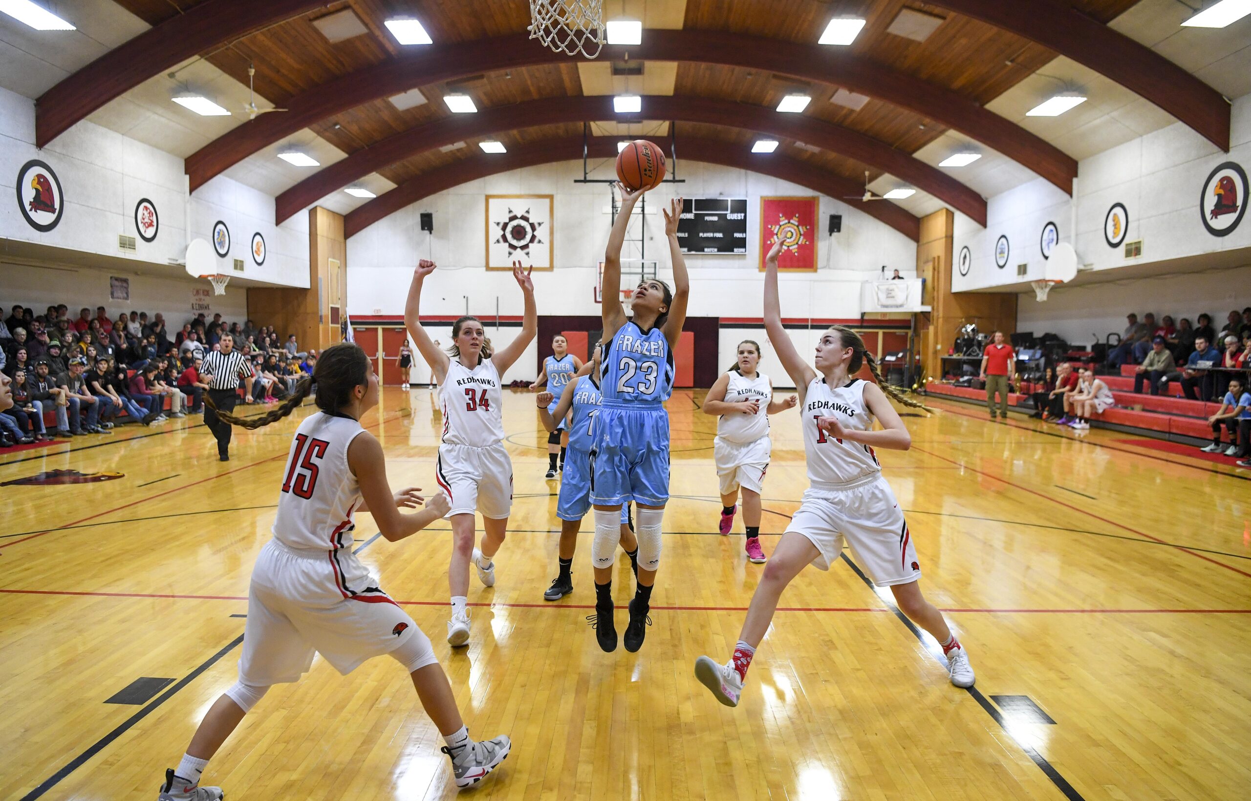 Native American girl's basketball team playing in a basketball game