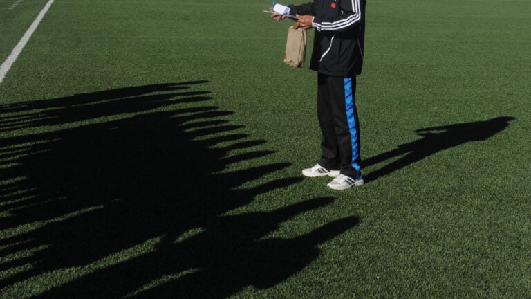 Shadows of Afghan female football players fall as their coach gives instructions prior to a football match in Kabul on November 9, 2013. Twelve teams played in Kabul with players to be selected for the Afghanistan National Women Football Team. AFP PHOTO/ Farshad USYAN (Photo credit should read FARSHAD USYAN/AFP via Getty Images)