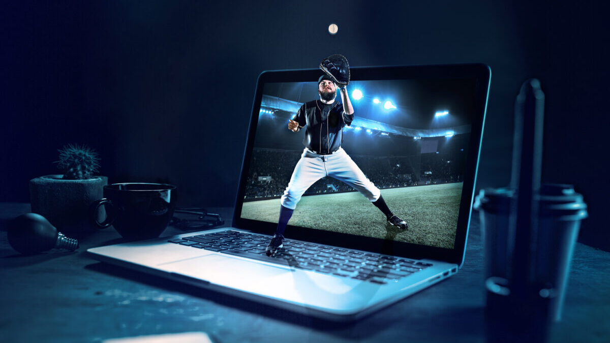 A baseball player catching the ball superimposed on a laptop